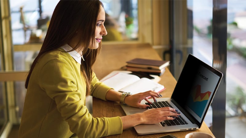 Woman working on a laptop with a 3M Privacy Screen